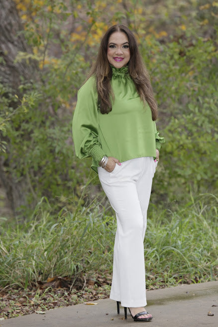 High neck blouse styled with trousers for elegant outfit.