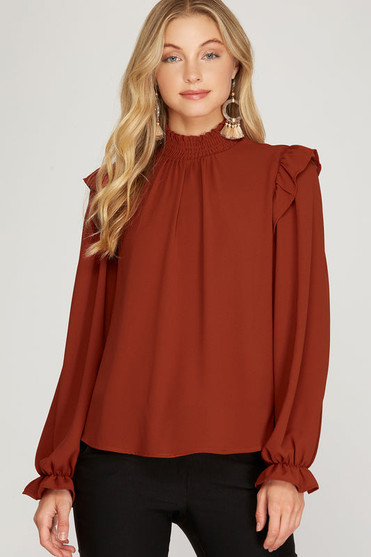 Rust color woven blouse with long sleeves.  